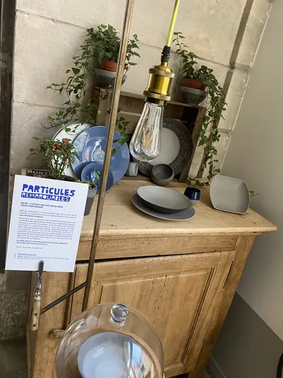 Vaisselle No.W de Revol exposée sur un buffet ancien, avec son cartel.